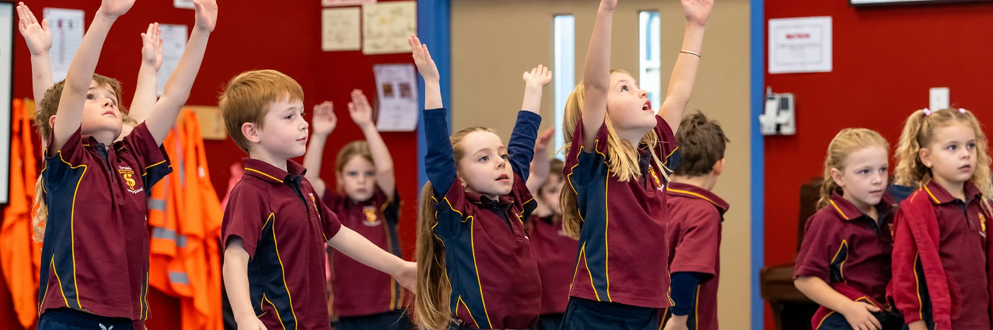 Students stretching their arms up during a class activity
